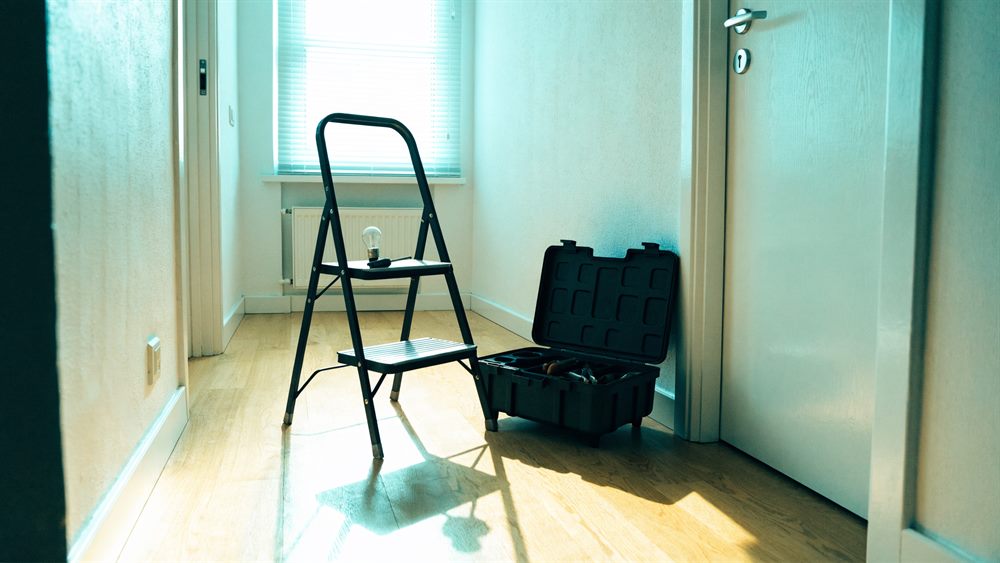 Trittleiter und geöffneter Werkzeugkoffer im hellen Flur einer Wohnung